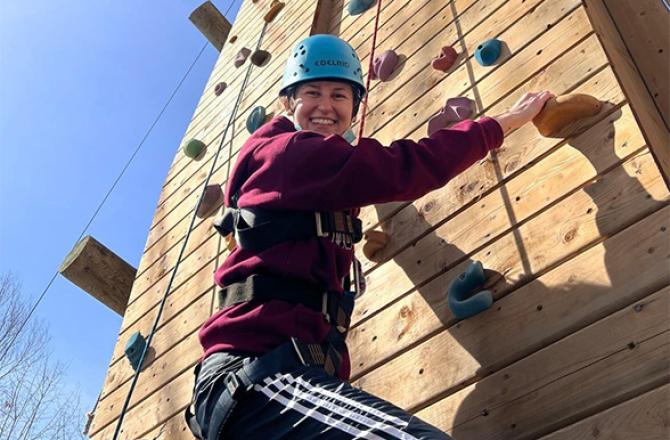 Smiling Mohawk College Recreation Therapy student on a climbing wall.