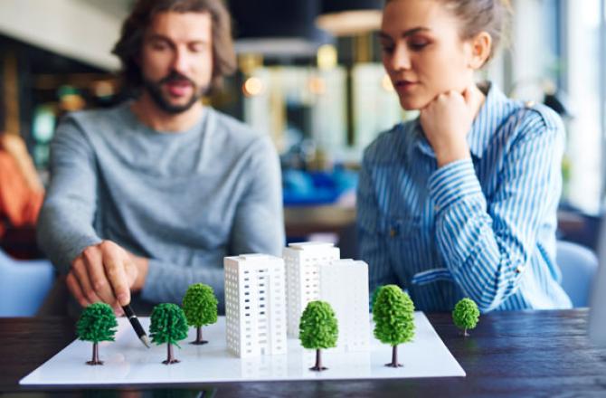 Planning technicians looking at an architectural model.