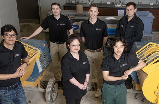 Students gathered among machinery
