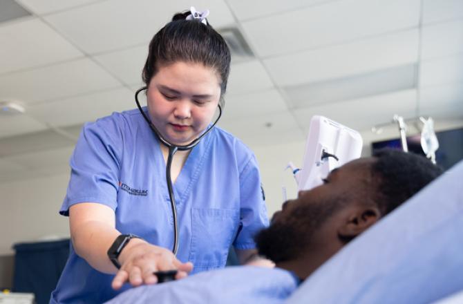 Mohawk College student listening heartbeat with stethoscope