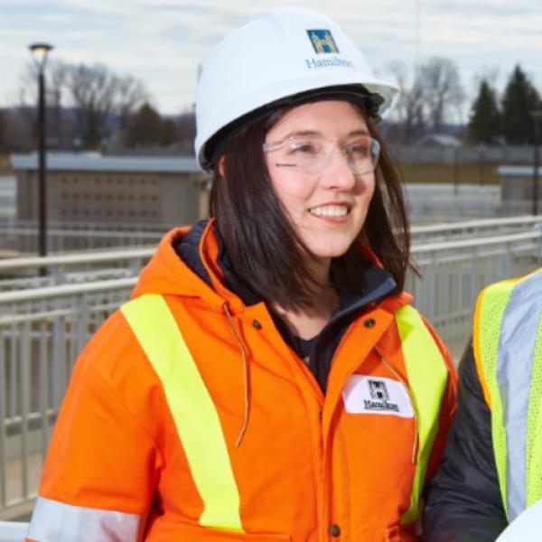 Woman surveys the water supply off-camera with co-worker.